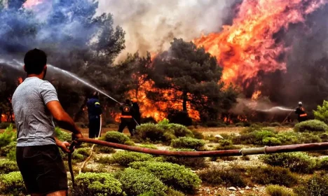 Bombeiros e voluntários ainda tentam controlar as chamas no litoral próximo a Atenas