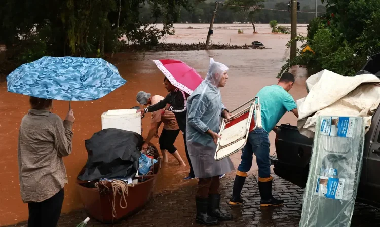 People rescue their belongings near a flooded area next to the Taquari River during heavy rains in the city of Encantado in Rio Grande do Sul, Brazil, May 1, 2024. REUTERS/Diego Vara