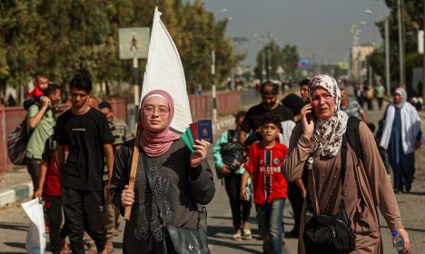 A Palestinian woman holds a white flag while evacuating with a group of civilians from the north of the Gaza Strip towards south, amid the ongoing conflict between Israel and Palestinian Islamist group Hamas, in the central Gaza Strip November 7, 2023. REUTERS/Ahmed Zakot