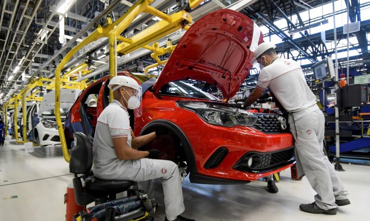 Os trabalhadores da montadora Fiat Chrysler Automobiles constroem um modelo Argo 2020, em meio à disseminação da doença por coronavírus (COVID-19), na fábrica de montagem em Betim