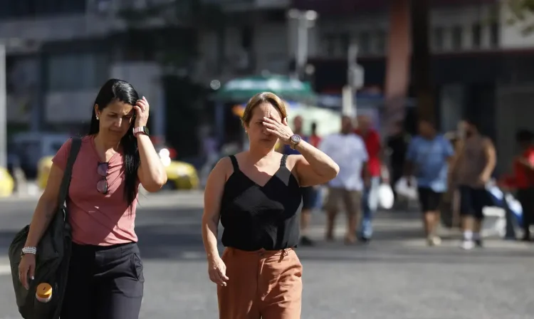 Rio de Janeiro (RJ), 26/12/2025 – Pessoas se protegem do sol no centro da cidade em dia de calor no Rio de Janeiro. Foto: Fernando Frazão/Agência Brasil