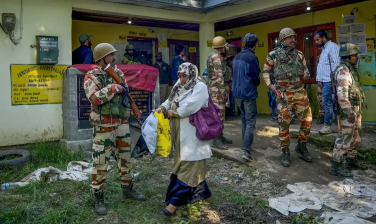 A woman leaves a polling station past Indian security force personnel standing guard during the fourth phase of India's general election on the outskirts of Srinagar May 13, 2024. REUTERS/Sanna Irshad Mattoo