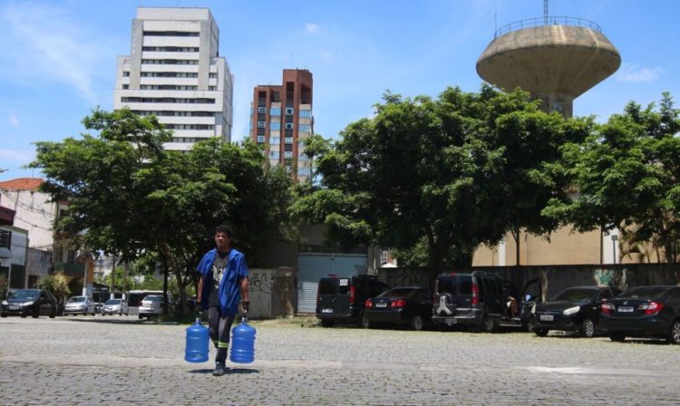 São Paulo (SP), 06/12/2023 - Homem carrega galões de água em frente o reservatório da Sabesp em Vila Mariana. Foto: Rovena Rosa/Agência Brasil