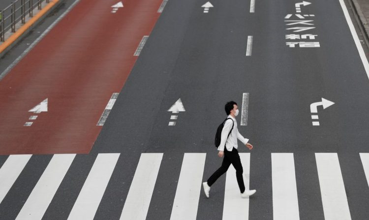 Um homem usando uma máscara protetora atravessa uma rua em Shinjuku, após o surto da doença por coronavírus (COVID-19), Tóquio, Japão, 4 de maio de 2020. REUTERS / Kim Kyung-Hoon