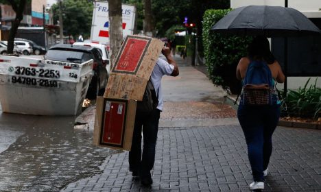 São Paulo (SP),14/03/2023 - Pessoas se protegem da chuva que deixa São Paulo em estado de atenção no final da tarde, na Rua Carlos Weber. Foto: Fernando Frazão/Agência Brasil