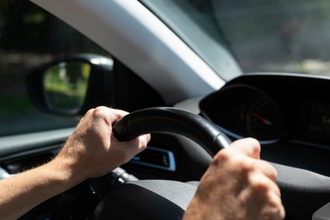 motorista-com-a-mao-no-volante-de-um-carro