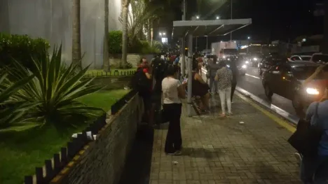 Pessoas na parada de ônibus a noite/ Foto: José Aldenir - Agora RN