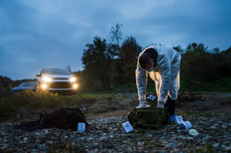 imagem mostra local de crime isolado com homem realizando trabalho de pericia