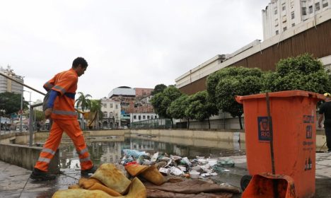 Garis recolhem lixo no sítio arqueológico do Cais do Valongo, na região portuária, alagado depois das chuvas.