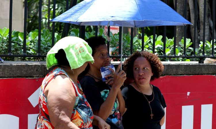 Rio de Janeiro (RJ), 12/11/2023 - Candidatos se protegem do forte calor enquanto aguardam abertura dos portões para o segundo dia provas do Enem 2023, na Universidade Veiga de Almeida, na Tijuca, zona norte da cidade. Foto: Tânia Rêgo/Agência Brasil