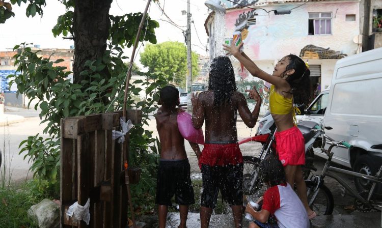Rio de Janeiro (RJ), 16/11/2023 - Moradores do Complexo da Maré se refrescam com chuveiros e piscinas improvisadas nas ruas da comunidade. A sensação térmica na cidade do Rio de Janeiro voltou a superar os 50 graus Celsius (°C), com a onda de calor que atinge boa parte do Brasil. Foto: Tânia Rêgo/Agência Brasil
