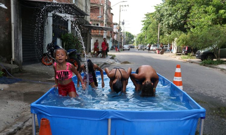 Rio de Janeiro (RJ), 16/11/2023 - Moradores do Complexo da Maré se refrescam com chuveiros e piscinas improvisadas nas ruas da comunidade. A sensação térmica na cidade do Rio de Janeiro voltou a superar os 50 graus Celsius (°C), com a onda de calor que atinge boa parte do Brasil. Foto: Tânia Rêgo/Agência Brasil